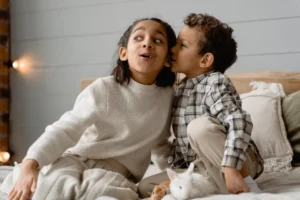 Two children whispering on a - Credits: pexels