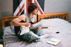 A young musician sits on - Credits: pexels