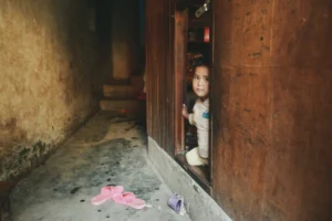 A young child curiously peers - Credits: pexels