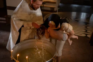 A child being baptized by - Credits: pexels