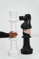 Two hands holding giant chess - Credits: pexels