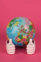 Vibrant globe figurine held by - Credits: pexels