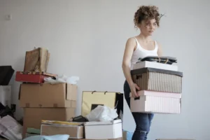 A young woman carrying boxes - Credits: pexels