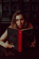 A woman intently reading a - Credits: pexels