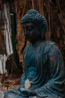 A weathered Buddha statue meditating - Credits: pexels