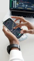 Hands using smartphone trading app - Credits: pexels