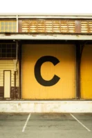 Yellow warehouse facade with letter - Credits: pexels