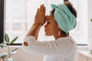 Woman practicing meditation indoors with - Credits: pexels