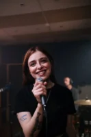 A cheerful female singer performs - Credits: pexels