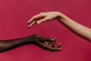 Two hands reaching towards each - Credits: pexels