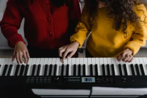 Two women playing electronic keyboard - Credits: pexels