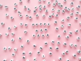 White beads forming 'Happy New - Credits: pexels