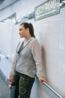 Woman in sportswear leaning against - Credits: pexels