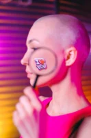 Young bald female with magnifying - Credits: pexels