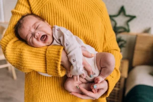A mother gently holds a - Credits: pexels