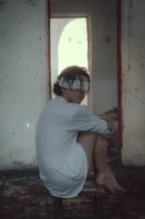 An individual blindfolded and seated - Credits: pexels
