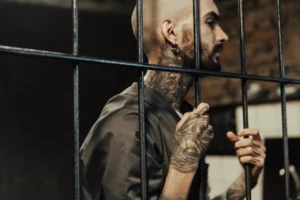 A tattooed man behind prison - Credits: pexels