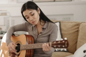 A woman playing an acoustic - Credits: pexels