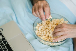 Hands reach for popcorn in - Credits: pexels