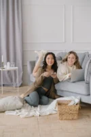 Two friends relaxing at home - Credits: pexels