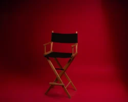 A wooden director's chair against - Credits: pexels