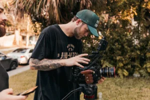 A young male cinematographer adjusts - Credits: pexels