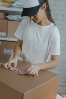 Woman preparing shipment by applying - Credits: pexels