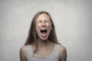 Young woman screaming with emotion, - Credits: pexels
