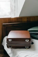 Elegant brown suitcase on bed, - Credits: pexels