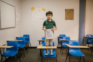 Child standing on desk in - Credits: pexels