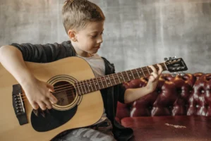 A young boy sitting indoors - Credits: pexels