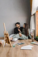 A couple smiles while painting - Credits: pexels
