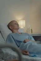 Bald woman in hospital bed - Credits: pexels