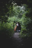 A woman playing harp in - Credits: pexels