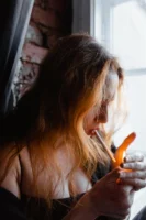 A woman lights a cigarette - Credits: pexels