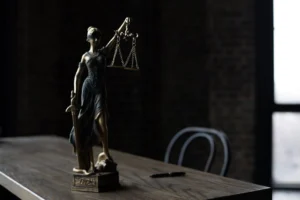 Lady Justice figurine on wooden - Credits: pexels