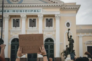 Crowd holding a sign 'MARIELLE - Credits: pexels