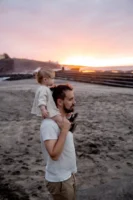 Father carries child on shoulders - Credits: pexels