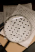 Magnifying glass revealing cryptic symbols - Credits: pexels