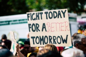 Crowd holding a protest sign - Credits: pexels