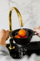 Close-up of hands washing oranges - Credits: pexels