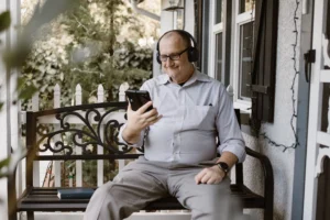 Senior man on porch engaging - Credits: pexels