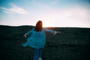 A woman joyfully runs across - Credits: pexels