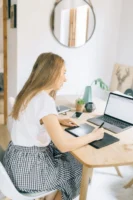 Young woman multitasking with laptop - Credits: pexels