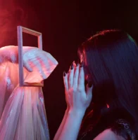 A woman covers her face, - Credits: pexels